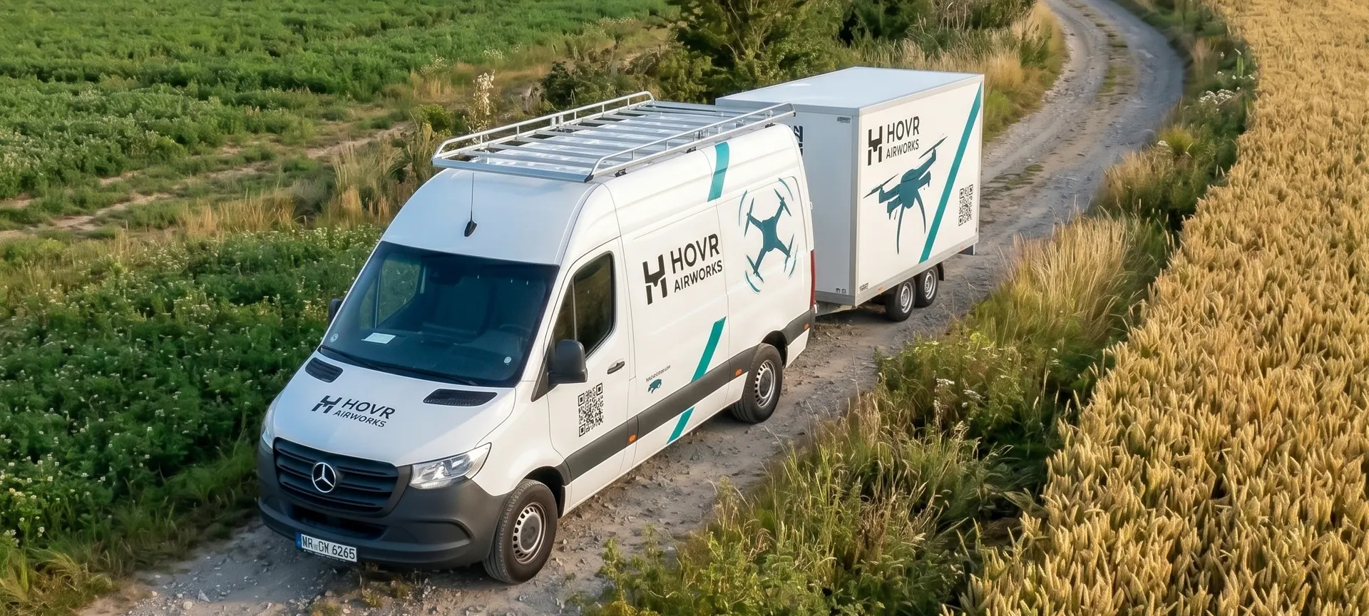 HOVR Einsatzfahrzeug mit Anh&auml;nger auf einem Feldweg zwischen Getreidefeldern